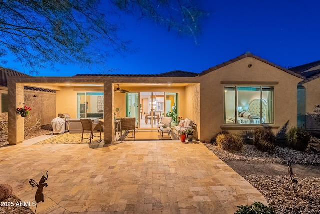 rear view of house with an outdoor living space, stucco siding, ceiling fan, and a patio area