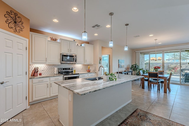 kitchen featuring visible vents, a sink, white cabinetry, appliances with stainless steel finishes, and decorative backsplash