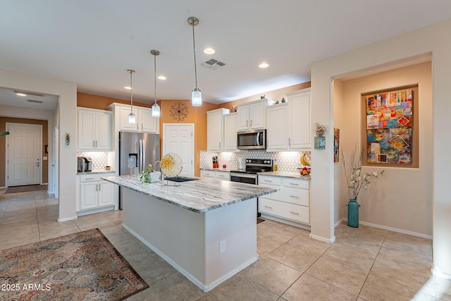 kitchen with light tile patterned flooring, backsplash, appliances with stainless steel finishes, and white cabinetry