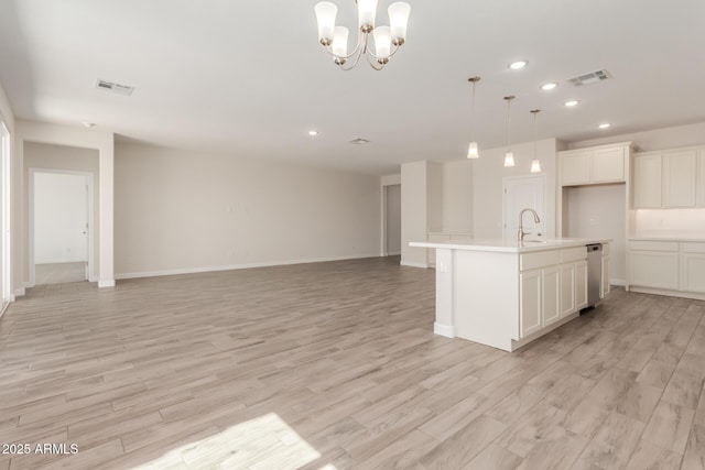 kitchen with light wood-type flooring, visible vents, pendant lighting, open floor plan, and light countertops