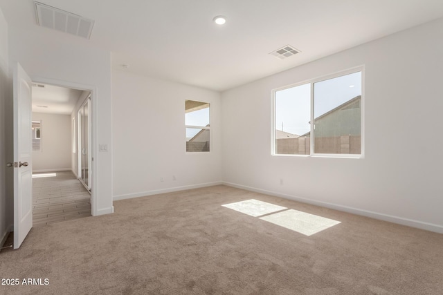carpeted spare room with recessed lighting, baseboards, and visible vents
