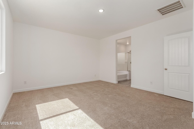 unfurnished bedroom featuring visible vents, baseboards, carpet, recessed lighting, and ensuite bath