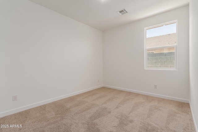 empty room with light colored carpet, visible vents, and baseboards