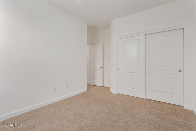 unfurnished bedroom with baseboards, a closet, and carpet floors