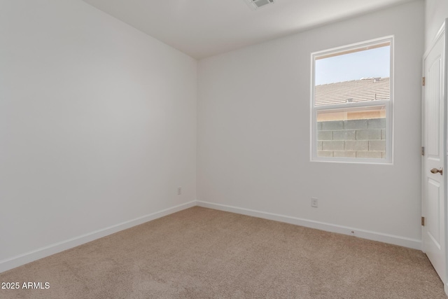 carpeted empty room featuring baseboards