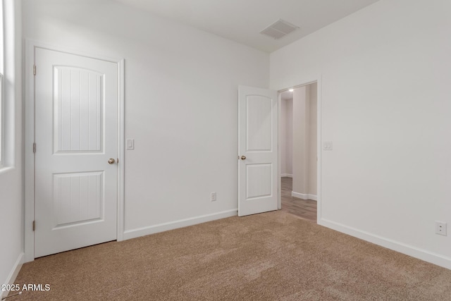 unfurnished bedroom with visible vents, carpet flooring, and baseboards