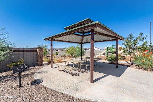 view of patio featuring a gazebo, fence, and playground community