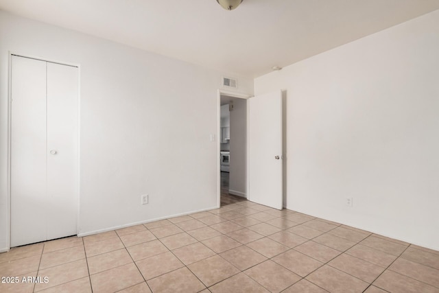 unfurnished bedroom with a closet and light tile patterned flooring