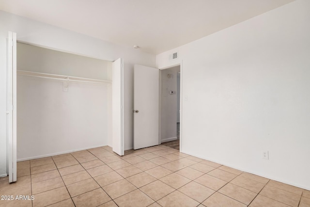 unfurnished bedroom with a closet and light tile patterned flooring