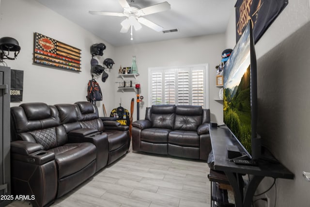 living room with ceiling fan and light hardwood / wood-style flooring