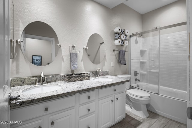 full bathroom with toilet, bath / shower combo with glass door, and vanity