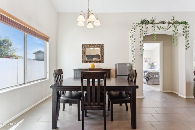 dining area with tile patterned flooring and a notable chandelier