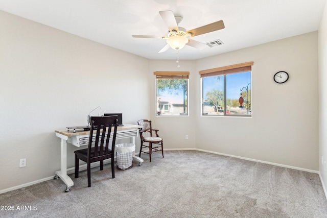 carpeted home office featuring ceiling fan