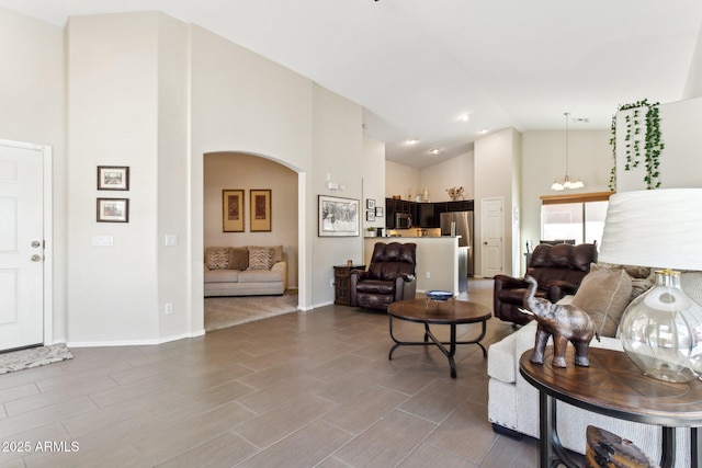 living room with an inviting chandelier and high vaulted ceiling