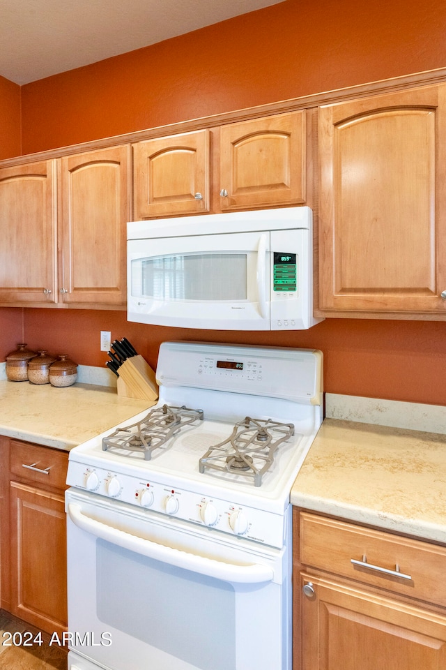 kitchen with white appliances and light brown cabinetry