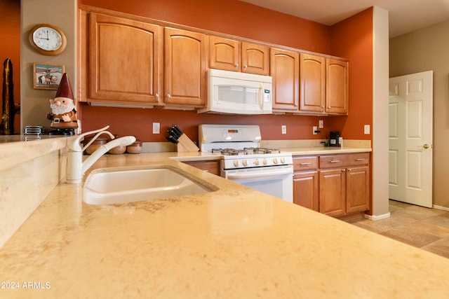 kitchen featuring light tile patterned floors, sink, and white appliances