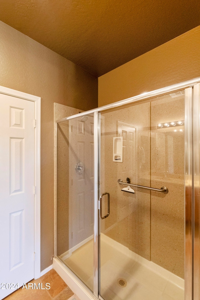 bathroom with tile patterned flooring and an enclosed shower