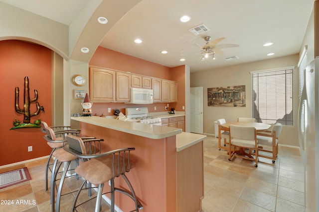 kitchen with ceiling fan, light brown cabinets, light tile patterned flooring, and white appliances