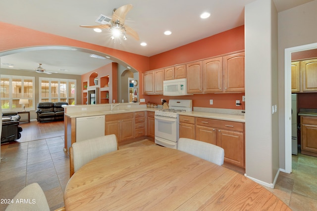 kitchen with light hardwood / wood-style flooring, sink, kitchen peninsula, white appliances, and ceiling fan