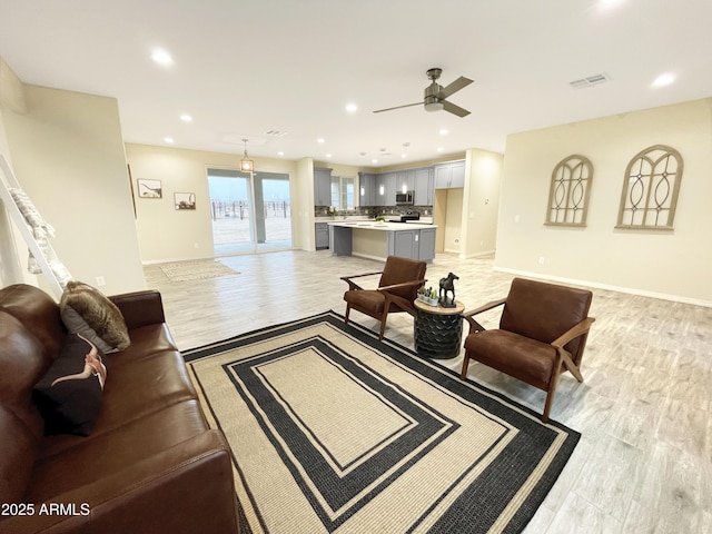 living room featuring light hardwood / wood-style flooring and ceiling fan