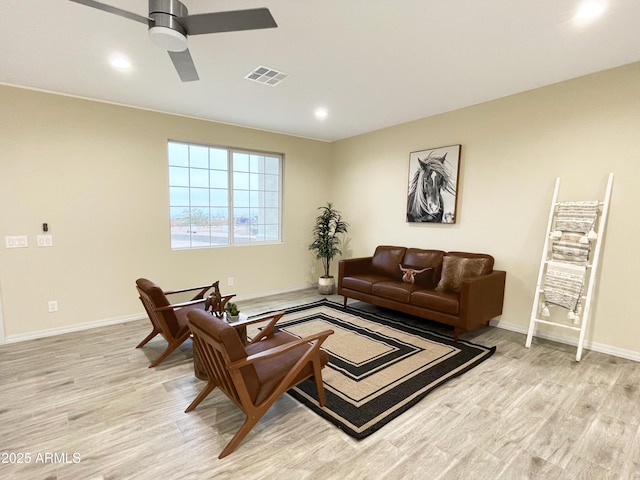 living room featuring light hardwood / wood-style flooring and ceiling fan