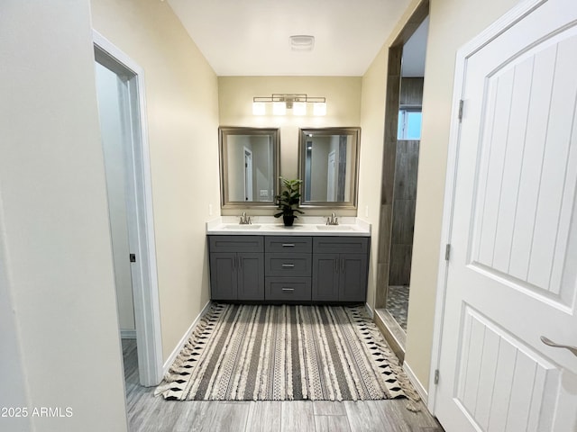 bathroom with a shower, wood-type flooring, and vanity