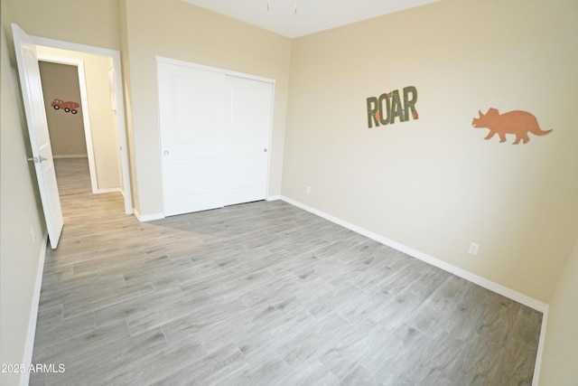 unfurnished bedroom with a closet and light hardwood / wood-style floors