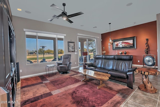 living room with ceiling fan, rail lighting, and dark tile patterned flooring