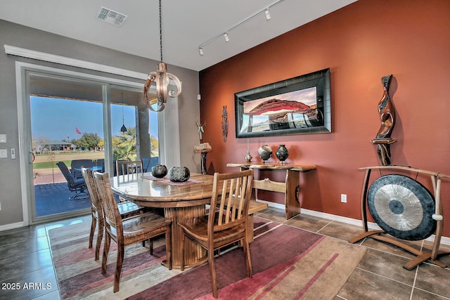 dining area with rail lighting and tile patterned flooring