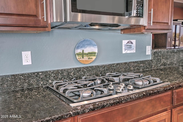 interior details featuring appliances with stainless steel finishes and dark stone counters