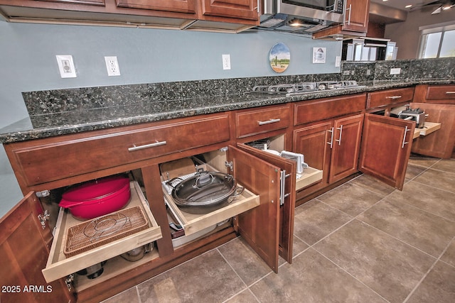 kitchen with stainless steel appliances, tile patterned flooring, and dark stone countertops