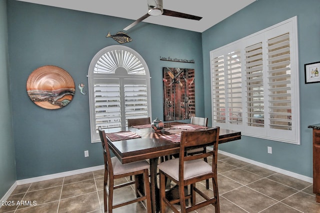 tiled dining space with ceiling fan and vaulted ceiling