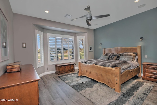 bedroom featuring hardwood / wood-style flooring, ceiling fan, and multiple windows