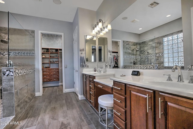 bathroom featuring tiled shower, vanity, and hardwood / wood-style floors