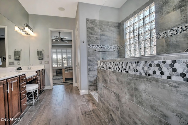 bathroom featuring vanity, hardwood / wood-style floors, ceiling fan, and a tile shower