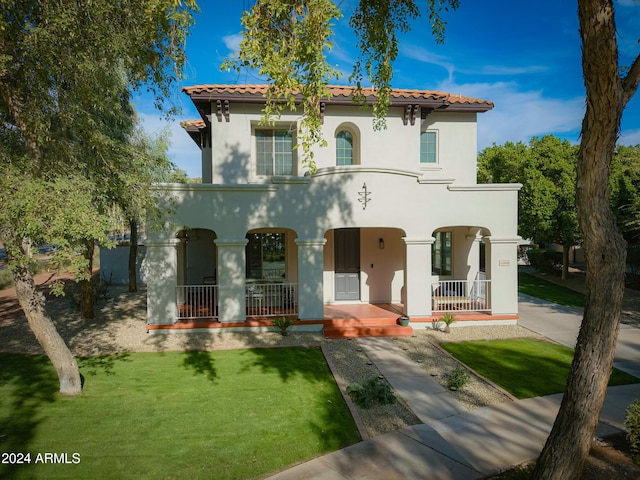 mediterranean / spanish-style home featuring covered porch and a front lawn