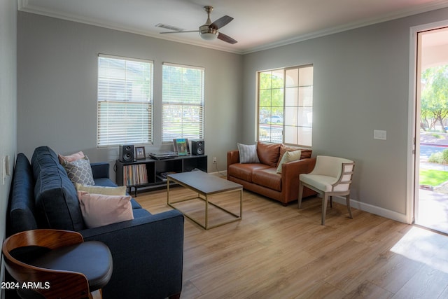 living room featuring ceiling fan, light wood-type flooring, and ornamental molding