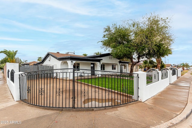 view of front facade with a fenced front yard, a gate, a front lawn, and stucco siding