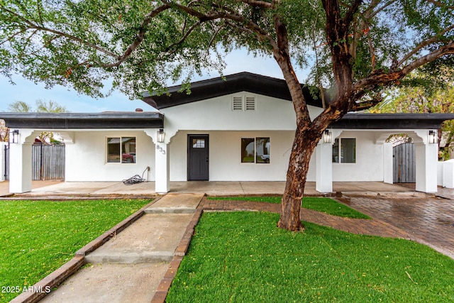 view of front of house with a front yard, fence, and stucco siding