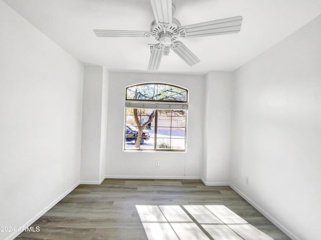 spare room with ceiling fan and wood-type flooring