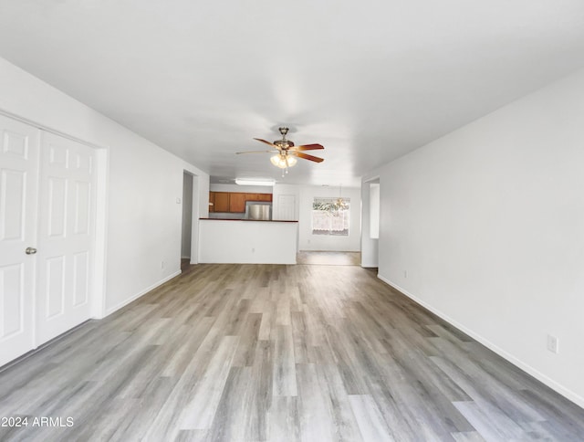 unfurnished living room featuring ceiling fan and light hardwood / wood-style floors