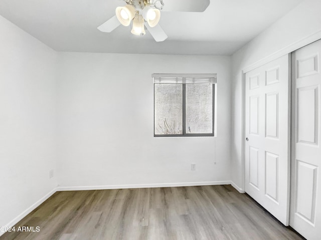 unfurnished bedroom with ceiling fan, light hardwood / wood-style floors, and a closet