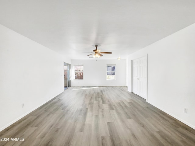 unfurnished living room with ceiling fan and light wood-type flooring