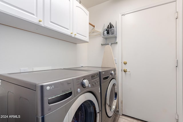 laundry room featuring cabinets, independent washer and dryer, and light tile patterned floors