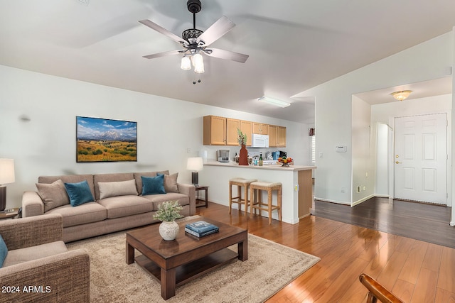 living room with lofted ceiling, light wood-type flooring, and ceiling fan