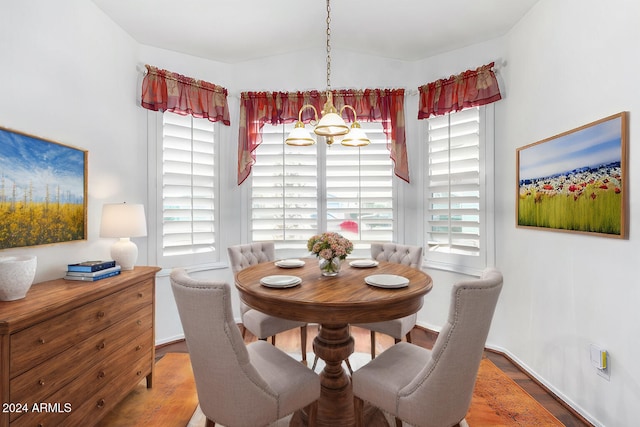 dining space featuring lofted ceiling, a chandelier, hardwood / wood-style flooring, and plenty of natural light