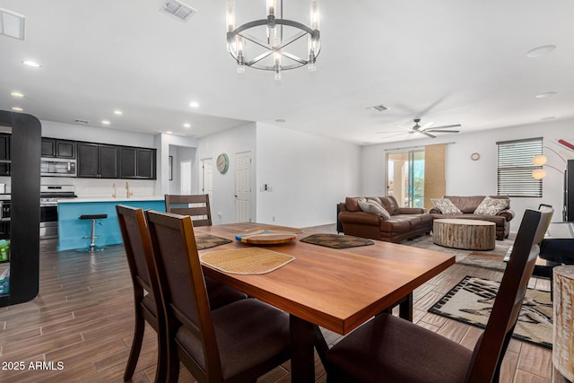 dining area featuring ceiling fan with notable chandelier