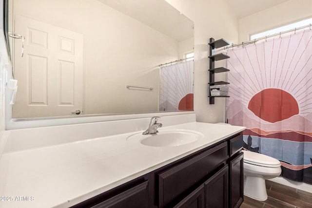 bathroom with vanity, toilet, curtained shower, and hardwood / wood-style floors