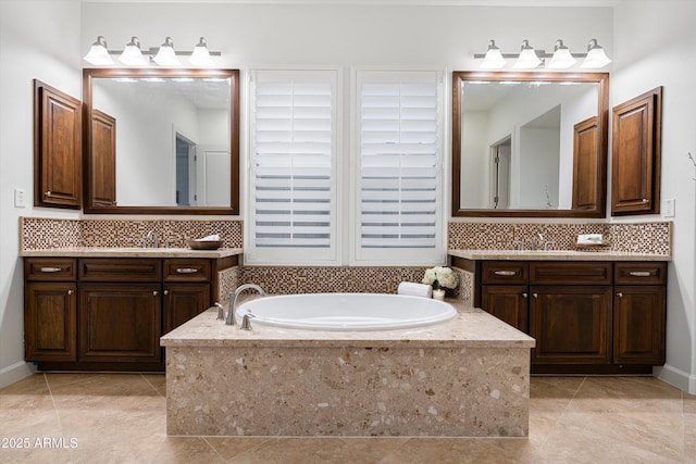 bathroom featuring a bath, decorative backsplash, a sink, and two vanities