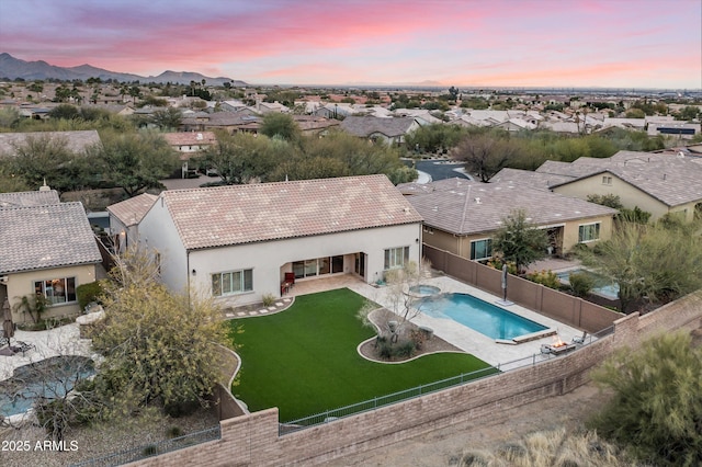 view of pool with a lawn, a fenced backyard, a mountain view, a residential view, and a patio area